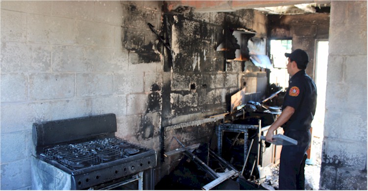Oficial Mercado evaluando los daños del fuego en el interior de la vivienda