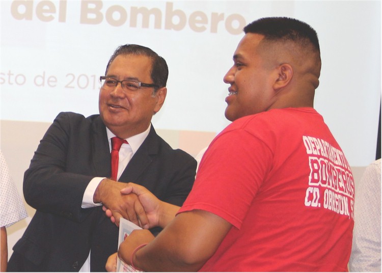 El Presidente Municipal felicita a Manuel el dia de su graduacion como Bombero